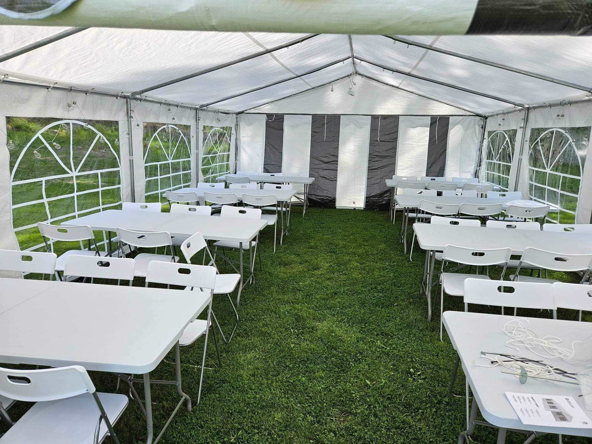 Partytelt 5x8 m innvendig med klappbord og stoler på plenen
